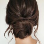 301037556357108397 wedding hairstyles for long hair low simple bun on dark hair with loose curls caraclyne.bridal l…